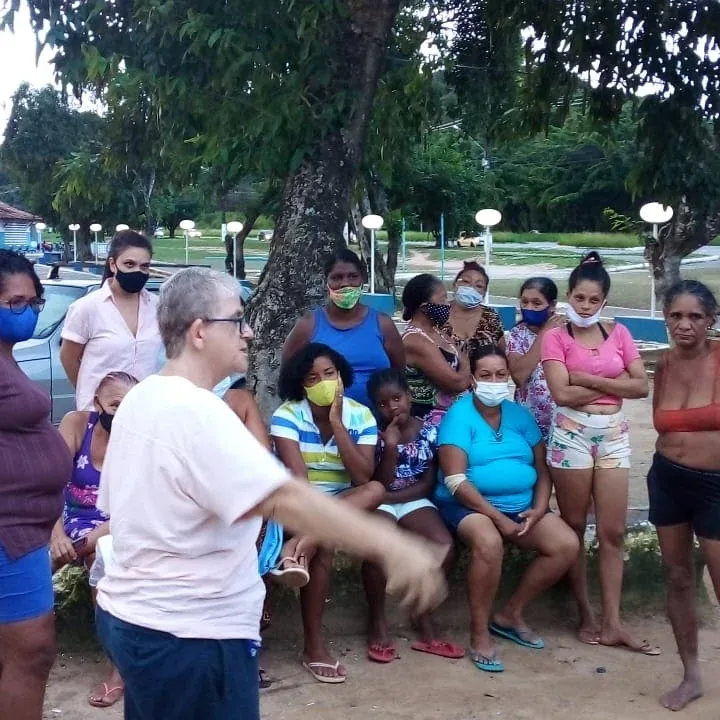 Pessoas em uma comunidade durante ação de coleta seletiva.