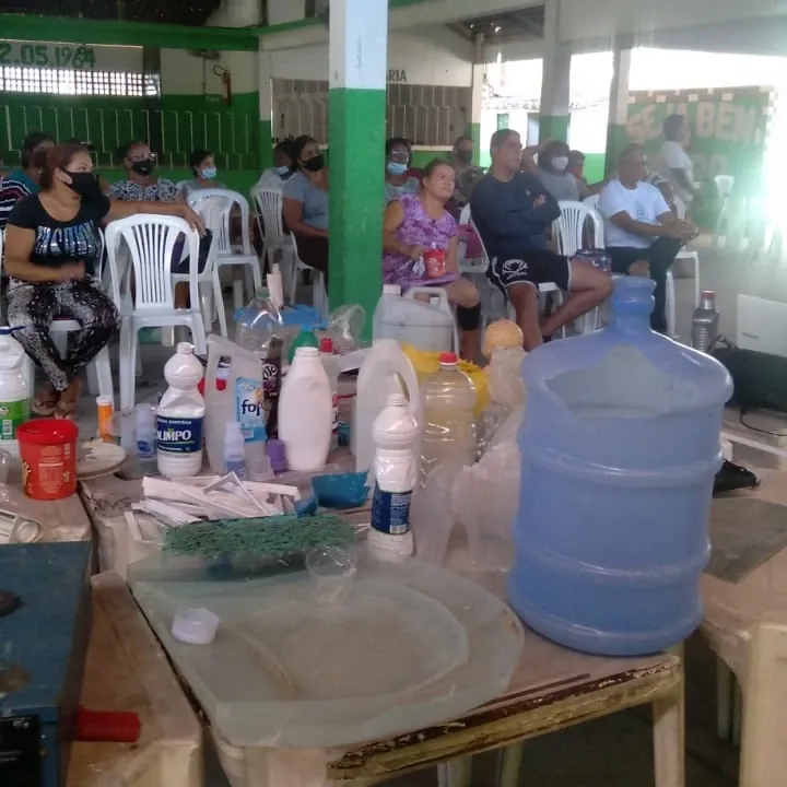 Mesa de capacitação em comunidade, com participantes ao redor.
