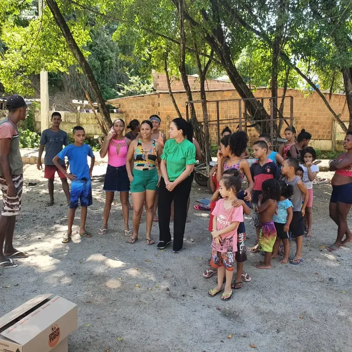 Grupo de pessoas em ação de distribuição de alimentos na rua.