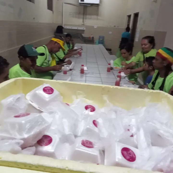 Grupo reunido em mesa durante um lanche comunitário.